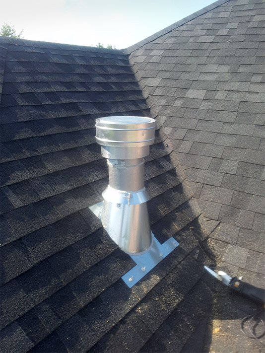 The homeowner chose to have the vent pipe exposed for this installation.  Note the purpose-built flashing and lapping of the shingles over the flashing to create a watertight barrier.